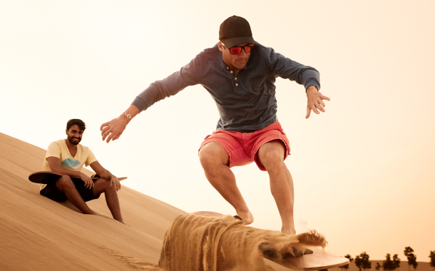 Sand boarding in the desert over the sand dunes